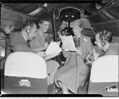Radio personality Clare Wallace and group broadcasting from inside Trans-Canada-Airlines airplane C. Late 30s