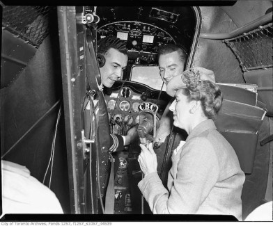 Radio personality Clare Wallace talking to pilots inside a Trans-Canada-Airlines airplane C. late 30s